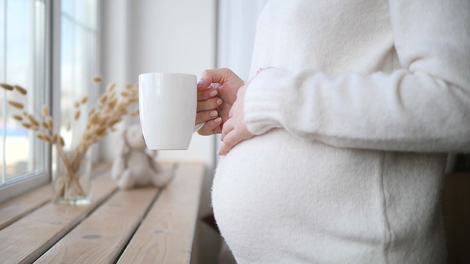 Schwangere Frau hält Teetasse